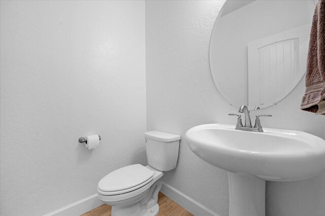 bathroom featuring sink, wood-type flooring, and toilet