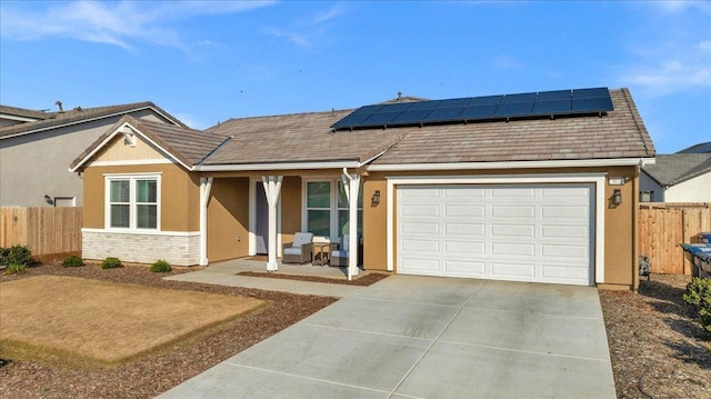 ranch-style house featuring a garage and solar panels