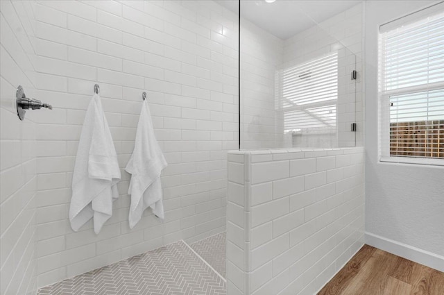 bathroom featuring tiled shower and hardwood / wood-style floors