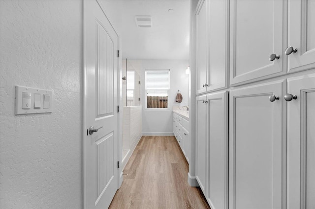 corridor with light hardwood / wood-style flooring