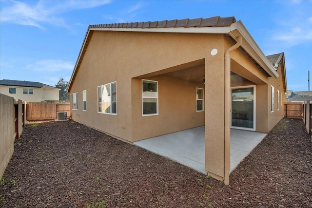 back of property with cooling unit and a patio