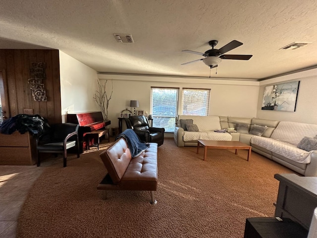 carpeted living room featuring a textured ceiling and ceiling fan