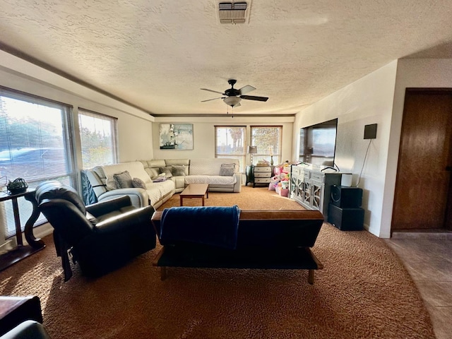 carpeted living room with ceiling fan and a textured ceiling