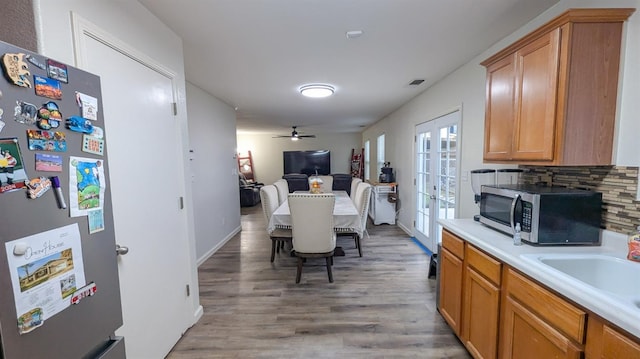 kitchen featuring french doors, sink, stainless steel appliances, hardwood / wood-style floors, and decorative backsplash