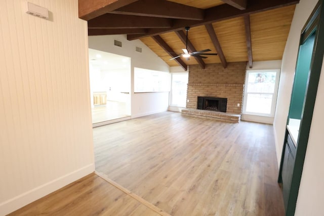 unfurnished living room with ceiling fan, wood-type flooring, lofted ceiling with beams, a brick fireplace, and wooden ceiling