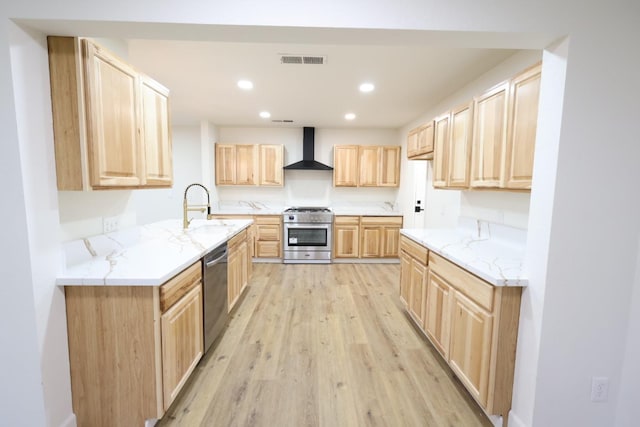 kitchen with sink, light hardwood / wood-style flooring, light brown cabinets, appliances with stainless steel finishes, and wall chimney range hood