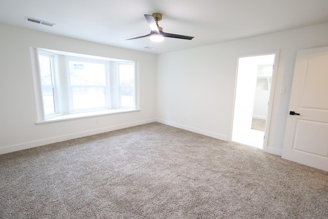 spare room featuring ceiling fan and carpet