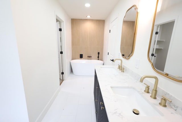 bathroom with vanity, a bath, and tile walls