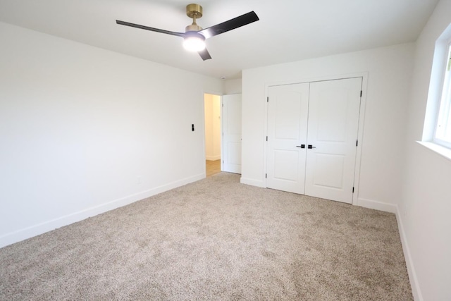 unfurnished bedroom with ceiling fan, light colored carpet, and a closet