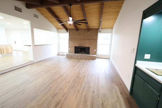 unfurnished living room featuring a brick fireplace, wood ceiling, light hardwood / wood-style flooring, and lofted ceiling with beams