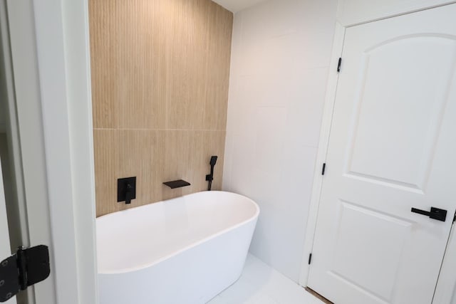 bathroom with tile walls, tile patterned floors, and a bathtub