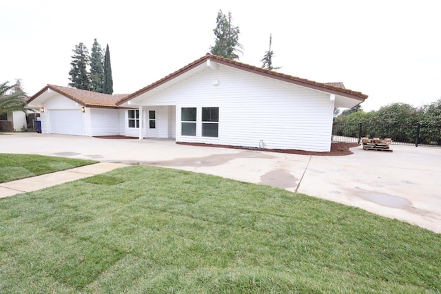 back of house with a garage and a yard