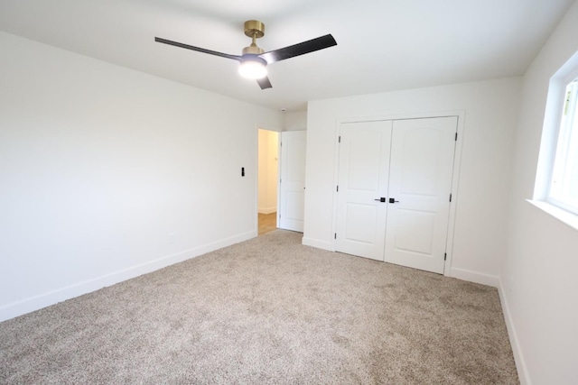 unfurnished bedroom with light carpet, ceiling fan, and a closet