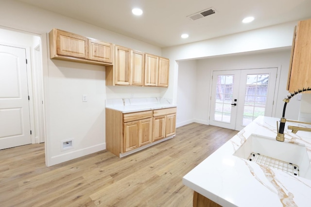 kitchen featuring light brown cabinetry, sink, light hardwood / wood-style floors, and french doors