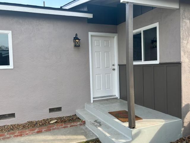 property entrance with crawl space and stucco siding