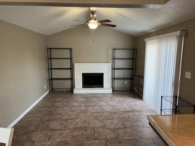 unfurnished living room with lofted ceiling, a fireplace, a ceiling fan, and baseboards