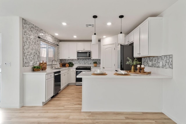 kitchen with stainless steel appliances, sink, and white cabinets