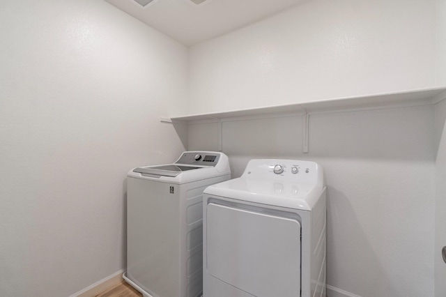 laundry room with hardwood / wood-style floors and washer and dryer