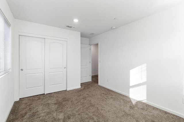 unfurnished bedroom with a closet and carpet