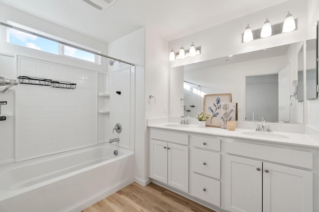 bathroom featuring tiled shower / bath combo, wood-type flooring, and vanity