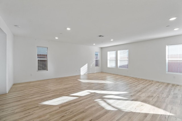 unfurnished living room with a wealth of natural light and light hardwood / wood-style flooring