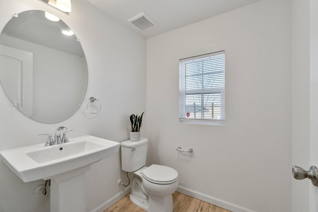 bathroom with hardwood / wood-style floors and toilet