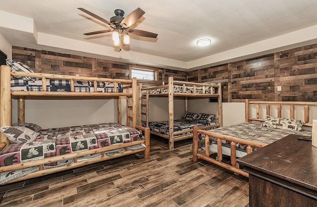 bedroom featuring wood-type flooring and wood walls