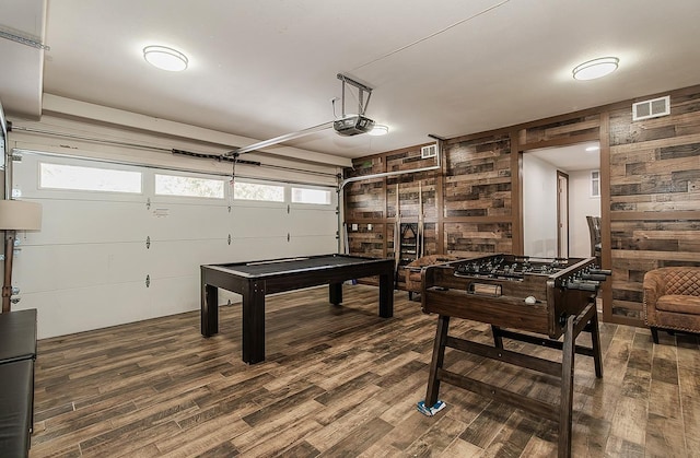 recreation room with dark wood-type flooring and wooden walls