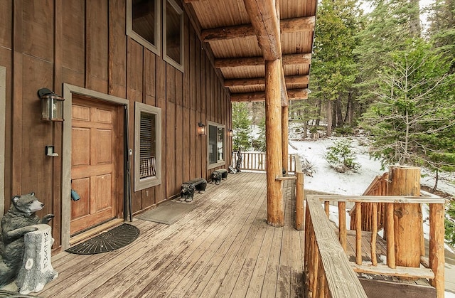 snow covered deck with a porch