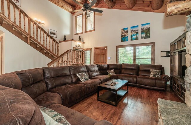 living room featuring lofted ceiling with beams, dark hardwood / wood-style floors, wooden ceiling, and ceiling fan