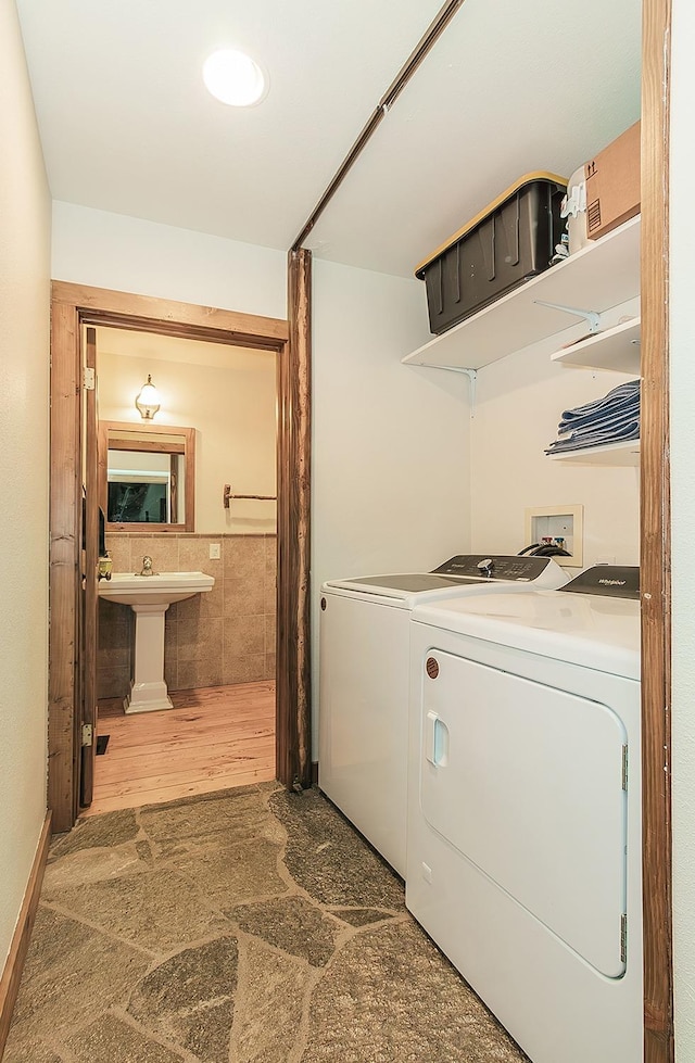 laundry room featuring hardwood / wood-style flooring, washer and dryer, and sink