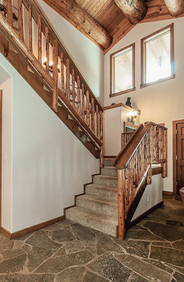stairs with high vaulted ceiling, beam ceiling, and wooden ceiling