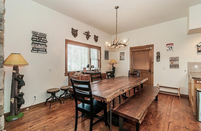 dining area with dark wood-type flooring and a chandelier