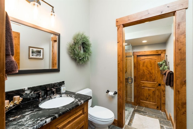 bathroom with vanity, toilet, and an enclosed shower