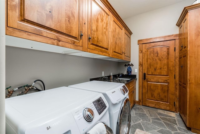 clothes washing area featuring separate washer and dryer, sink, and cabinets