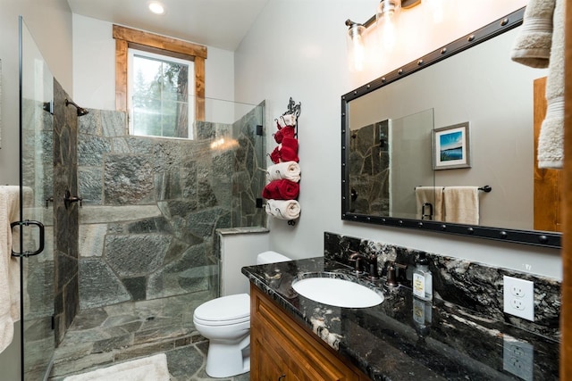 bathroom featuring vanity, toilet, and an enclosed shower