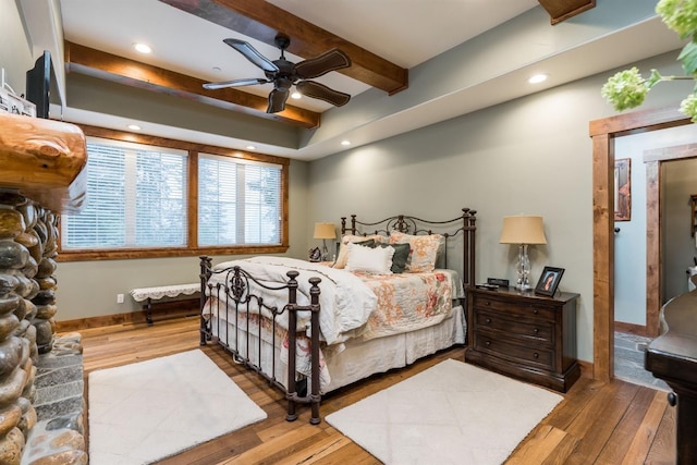 bedroom featuring ceiling fan, wood-type flooring, and beam ceiling