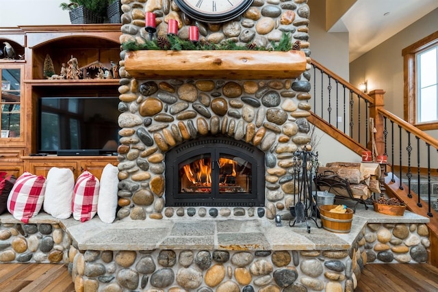 details featuring hardwood / wood-style flooring and a stone fireplace