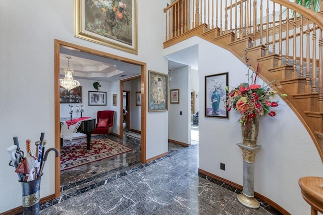 entryway featuring a towering ceiling and a raised ceiling