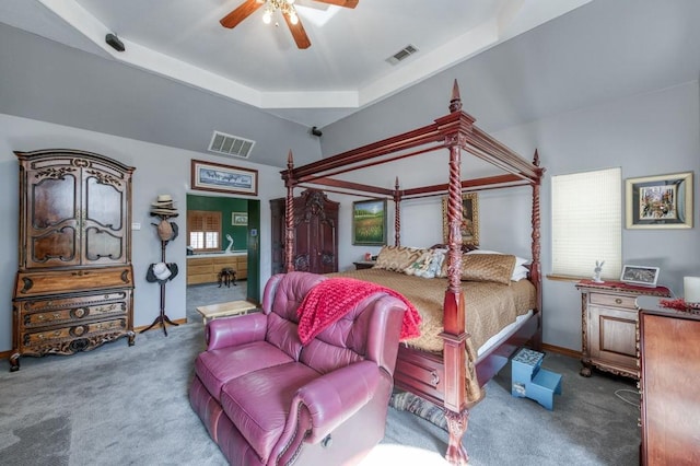 bedroom featuring multiple windows, dark carpet, a raised ceiling, and ceiling fan