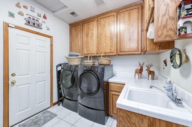 washroom with independent washer and dryer, sink, cabinets, and light tile patterned flooring