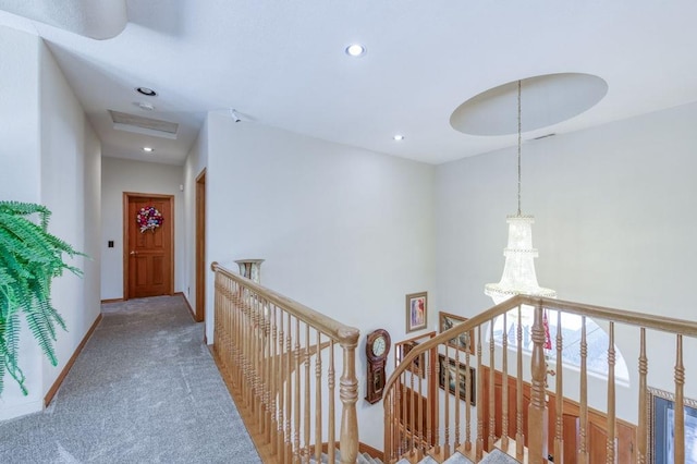 hallway with carpet floors and a notable chandelier