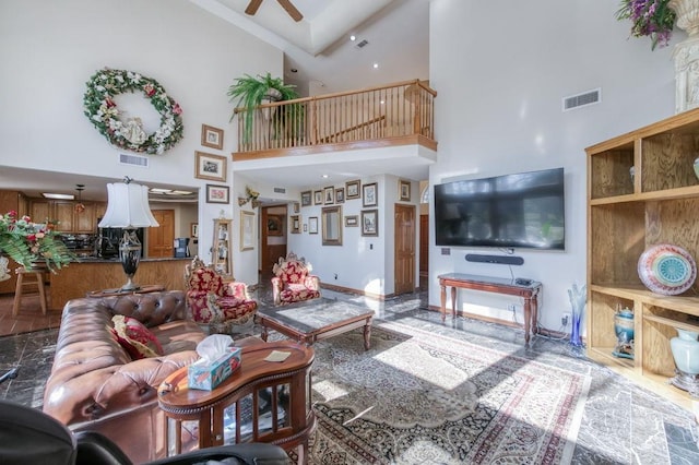 living room featuring ceiling fan and a high ceiling