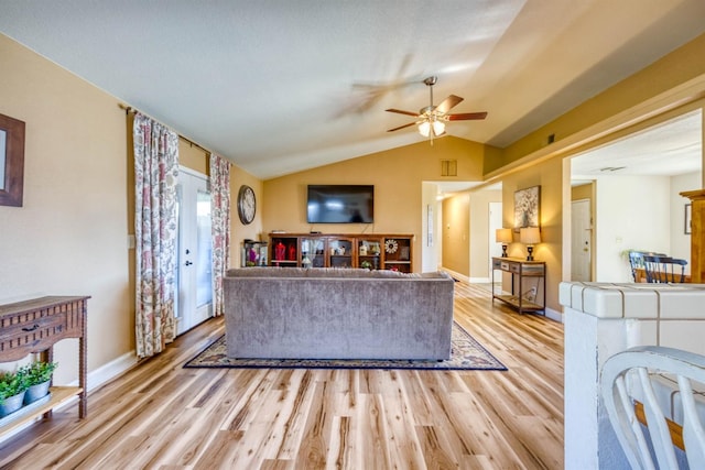 living room featuring lofted ceiling, light hardwood / wood-style floors, and ceiling fan