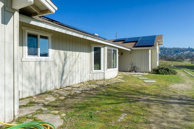 view of home's exterior with a yard and solar panels