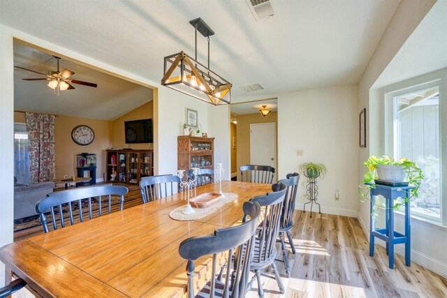 dining space featuring ceiling fan, vaulted ceiling, and light hardwood / wood-style flooring