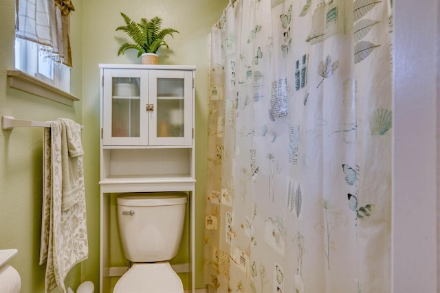 bathroom with curtained shower and toilet