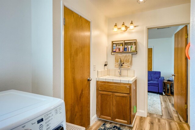 bathroom with washer / clothes dryer, vanity, and hardwood / wood-style flooring