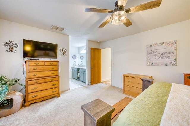 carpeted bedroom with ceiling fan and ensuite bath