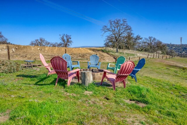 view of yard with a fire pit and a rural view